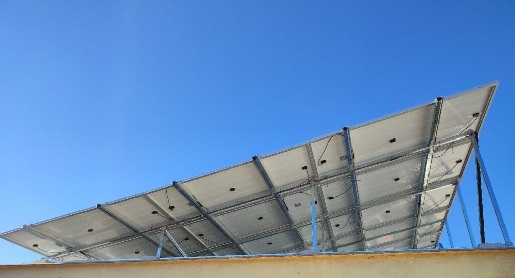 La imagen muestra placas solares instaladas en el techo de un edificio.